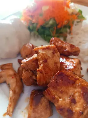 a plate of food with chicken wings and broccoli at hosteria y camping piedras verdes in Sopetran
