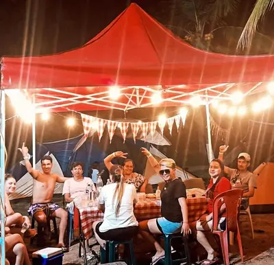 a group of people sitting at a table under a tent at hosteria y camping piedras verdes in Sopetran