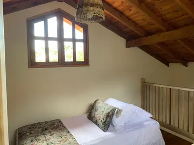 a bedroom with a bed with a window and a crib at Casa Calandria - Vive Jardin in Jardin