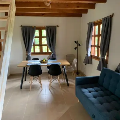 a living room with a blue couch and a table at Casa Calandria - Vive Jardin in Jardin