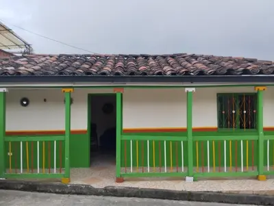 a green and white building with a green door at Casa finca en pueblo rico Neira in Neira