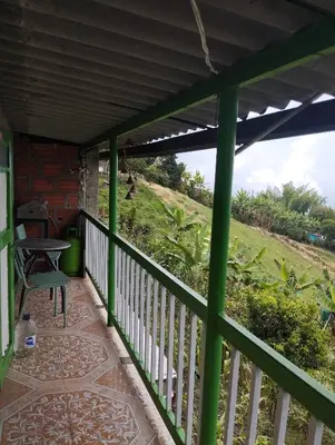 a green porch with a table and a view of a hill at Casa finca en pueblo rico Neira in Neira