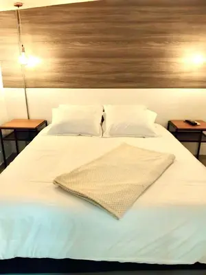 a white bed with two nightstands and two tables at Urban Oasis Med in Medellín