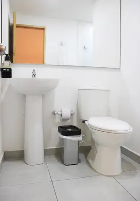 a bathroom with a white toilet and a sink at Urban Oasis Med in Medellín