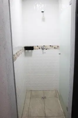 a bathroom with a shower with white tiles at Urban Oasis Med in Medellín