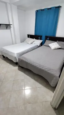 two beds sitting next to each other in a bedroom at Hotel Los Colores GUATAPE in Guatapé