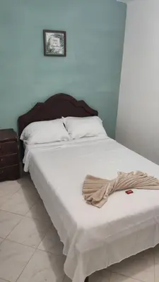 a bed in a room with a blanket on it at Hotel Los Colores GUATAPE in Guatapé