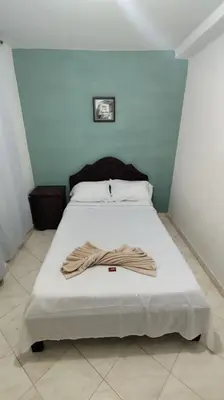 a bed in a room with a blue wall at Hotel Los Colores GUATAPE in Guatapé