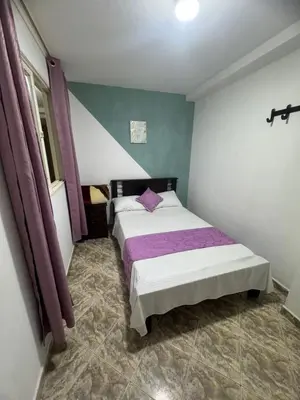 a bedroom with a large bed with purple sheets at Hotel Los Colores GUATAPE in Guatapé