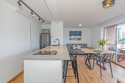 a kitchen and dining room with a table and chairs at Torre Pravia By Host Medellin in Medellín