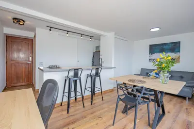 a kitchen and living room with a table and chairs at Torre Pravia By Host Medellin in Medellín