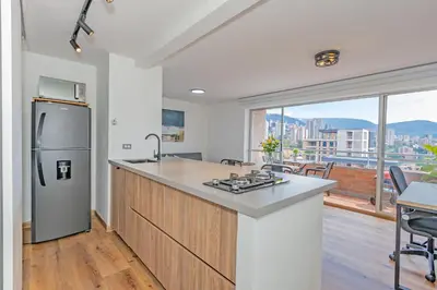 a kitchen with a stainless steel refrigerator and a counter at Torre Pravia By Host Medellin in Medellín