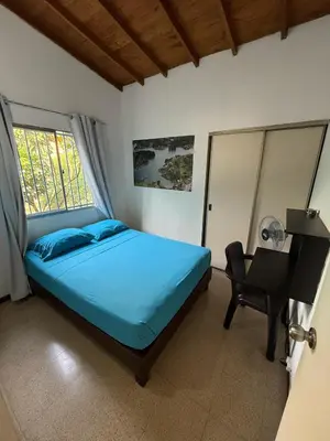 a bedroom with a bed and a desk and a window at Apartamento Sosiego in Medellín