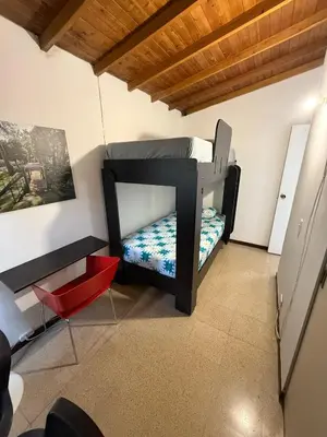 a bedroom with a bunk bed and a red chair at Apartamento Sosiego in Medellín