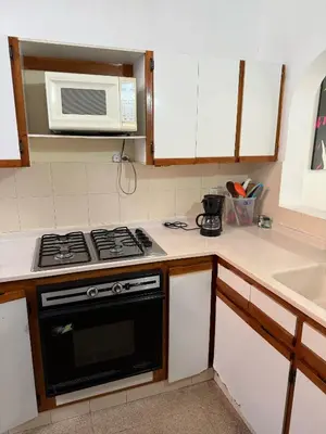 a kitchen with a stove and a microwave at Apartamento Sosiego in Medellín