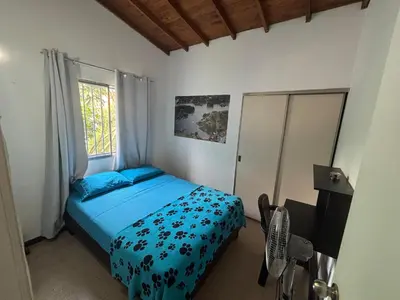 a bedroom with a bed with blue sheets and a window at Apartamento Sosiego in Medellín