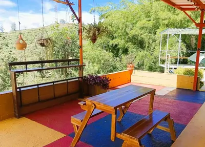 a patio with a table and a bench on a rug at Hotel Campestre Alto lindo en Guatapé in Guatapé