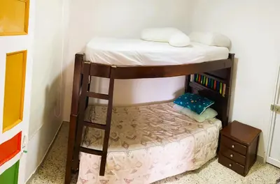 a bunk bed with a chair in a room at Hotel Campestre Alto lindo en Guatapé in Guatapé