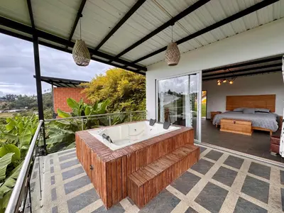 a large bathroom with a tub and a bedroom at Hotel Campestre Alto lindo en Guatapé in Guatapé