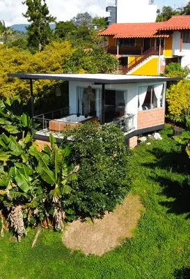 a house with a green yard with bushes at Hotel Campestre Alto lindo en Guatapé in Guatapé