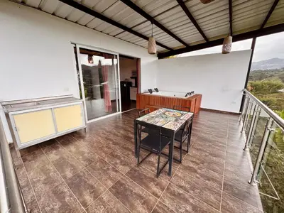 a room with a table and a balcony at Hotel Campestre Alto lindo en Guatapé in Guatapé