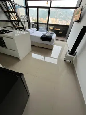 a room with a bed and a stove and windows at Suite ps8 in Medellín