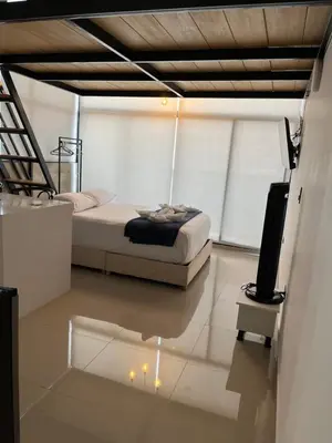 a bedroom with a bed and a tv on the floor at Suite ps8 in Medellín