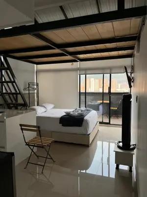 a bedroom with a bed and a table and a chair at Suite ps8 in Medellín