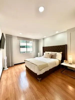 a bedroom with a large bed and a large window at Hermoso apartamento en El Poblado in Medellín