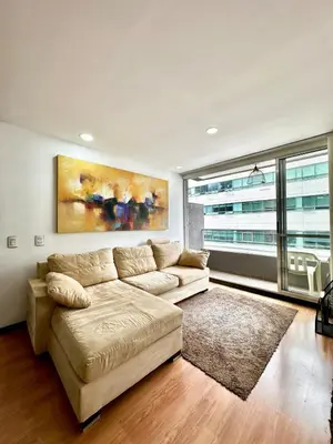 a living room with a couch and a large window at Hermoso apartamento en El Poblado in Medellín