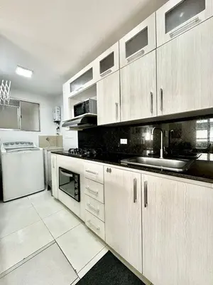 a kitchen with white cabinets and a sink and a dishwasher at Hermoso apartamento en El Poblado in Medellín