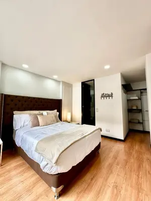 a bedroom with a large bed with a wooden headboard at Hermoso apartamento en El Poblado in Medellín