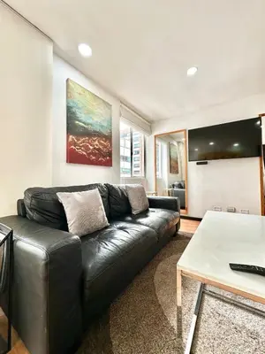 a living room with a leather couch and a table at Hermoso apartamento en El Poblado in Medellín