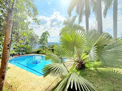 a swimming pool with palm trees next to a resort at Paradise San Jeronimo Parcelacion 6BR AC Pool in San Jerónimo
