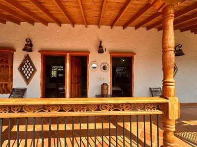 a porch of a house with a wooden railing at Paradise San Jeronimo Parcelacion 6BR AC Pool in San Jerónimo