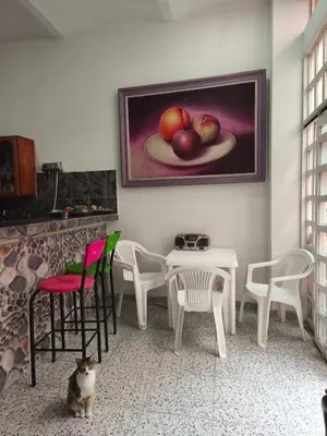 a table and chairs with a painting on the wall at Casa Prado Centro in Medellín