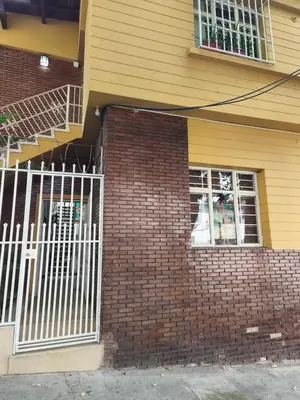 a brick house with a white gate and a building at Casa Prado Centro in Medellín