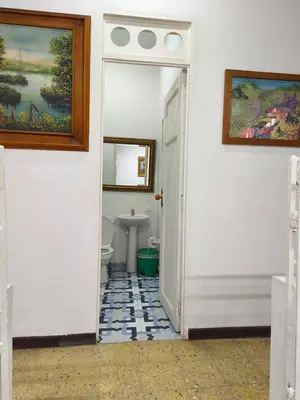 a hallway with a bathroom with a sink and a toilet at Casa Prado Centro in Medellín