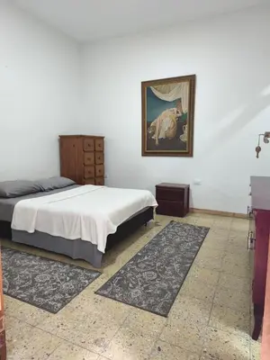 a bedroom with a bed and a painting on the wall at Casa Prado Centro in Medellín