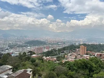 a view of a city with buildings and mountains at Apartamento alto de palmas in Medellín