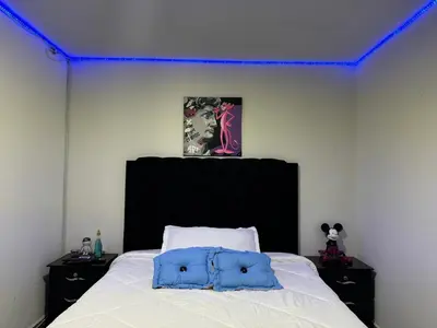 a bedroom with a white bed with a black headboard at Apartamento alto de palmas in Medellín