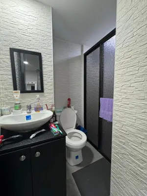 a bathroom with a white toilet and a sink at Apartamento alto de palmas in Medellín