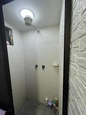 a bathroom with a shower with three fixtures on the wall at Apartamento alto de palmas in Medellín