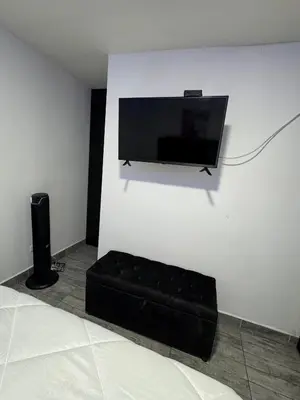 a flat screen tv hanging on a white wall at Apartamento alto de palmas in Medellín
