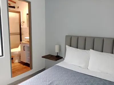 a bedroom with a bed and a bathroom with a mirror at Envigado tradicion y modernidad in Envigado