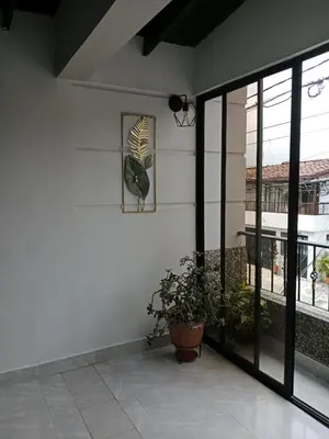 a white wall with a window and a plant at Envigado tradicion y modernidad in Envigado