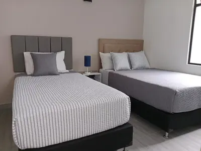 two beds in a room with two beds sidx sidx sidx at Envigado tradicion y modernidad in Envigado