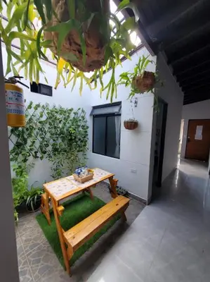 a table and bench in a room with a plant at Envigado tradicion y modernidad in Envigado
