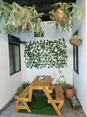 a picnic table in a patio with plants on the wall at Envigado tradicion y modernidad in Envigado