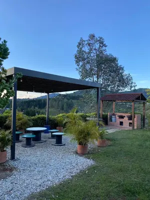 a picnic shelter with tables and potted plants in a park at Finca Oriente Antioqueño Guarne Rionegro in Guarne